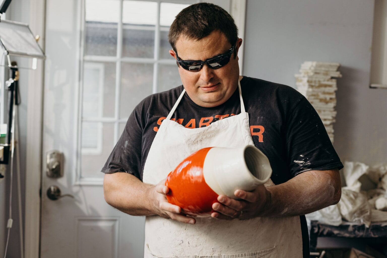 Kelvin holding a vase in the pottery studio